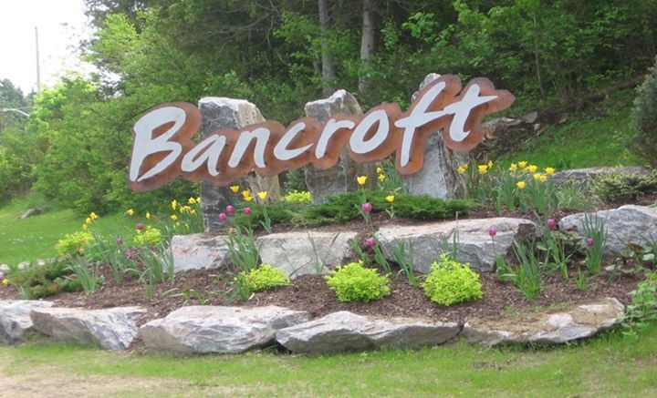 The Bancroft, Ontario welcome sign in the Hastings Highlands; Van Blanc trucks shipping containers up to Bancroft cottage and mining country.