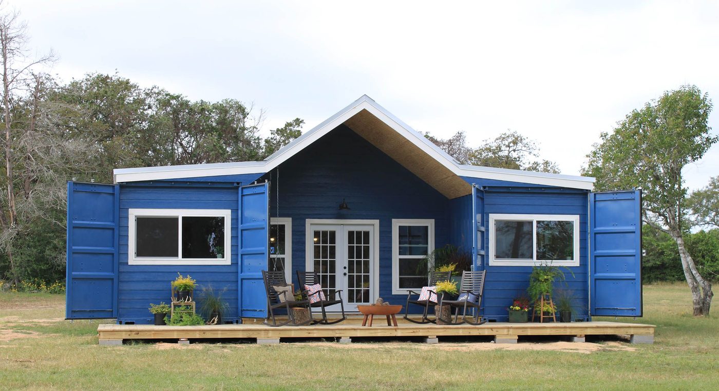 A blue multi-container home with a raised deck, built from the steel shipping containers Van Blanc supplies to builders across Ontario.