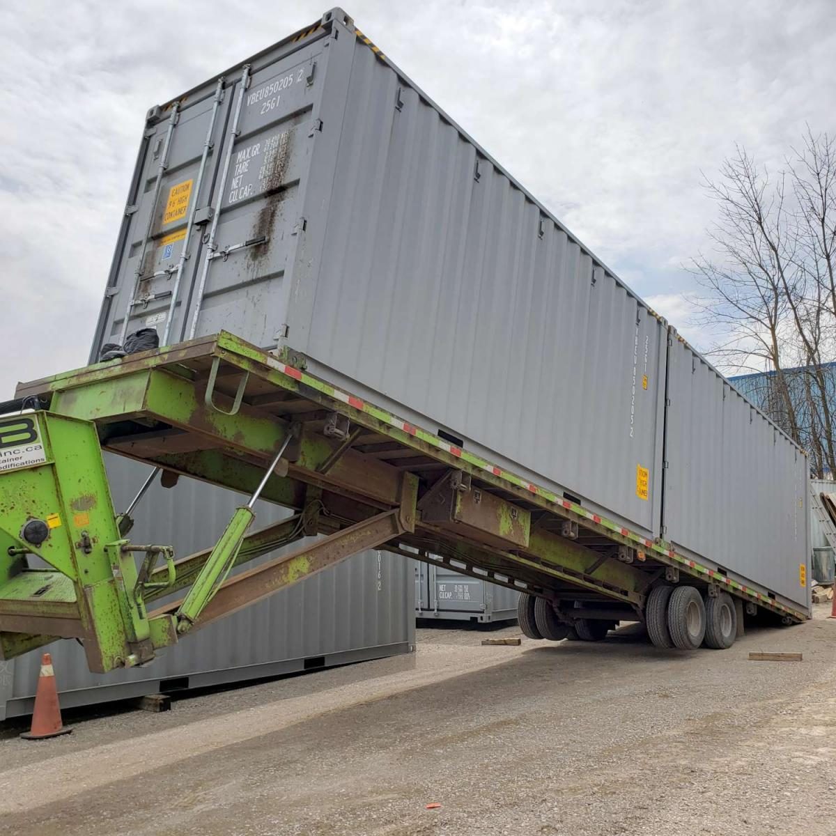 A shipping container delivered on a tilt-deck truck to a driveway, the way Van Blanc drops the box you load for an Ontario move