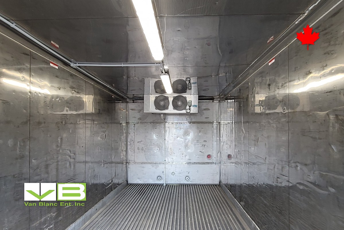 Refrigerated container interior with ceiling evaporator fans and aluminum t-bar floor.