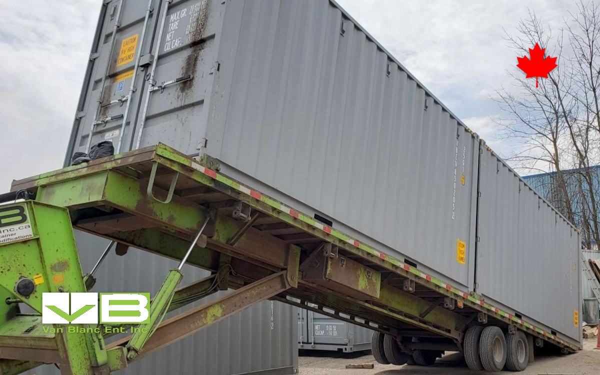 Forty-foot container loaded onto a tilt-deck trailer before leaving the yard