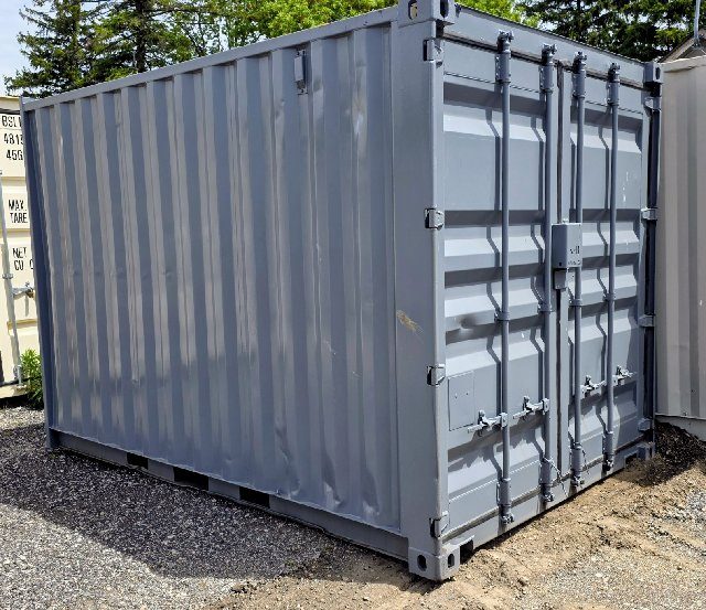 Repainted grey 12 foot container on gravel, with cargo doors, a lockbox at the centre seam and forklift pockets along the bottom rail
