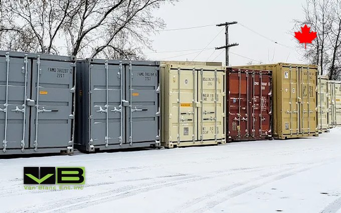 Grey, tan and red shipping containers standing in a row on packed snow at the Brantford yard under a white winter sky