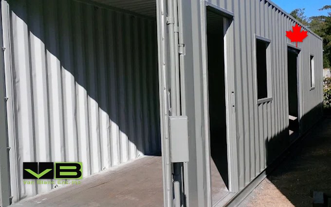 A modified shipping container fitted with a personnel door and a roll-up door, parked in the yard