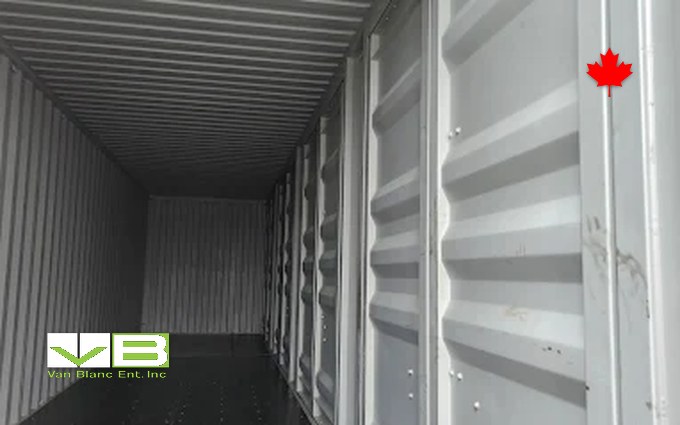 Looking down the length of an empty 40-foot shipping container with a plywood floor and corrugated walls, the space a paddle fleet's racks bolt into