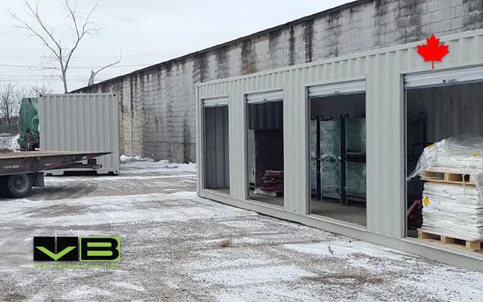 A row of grey shipping containers fitted with white roll-up doors on a gravel yard in Brantford, the steel alternative to a fabric garage