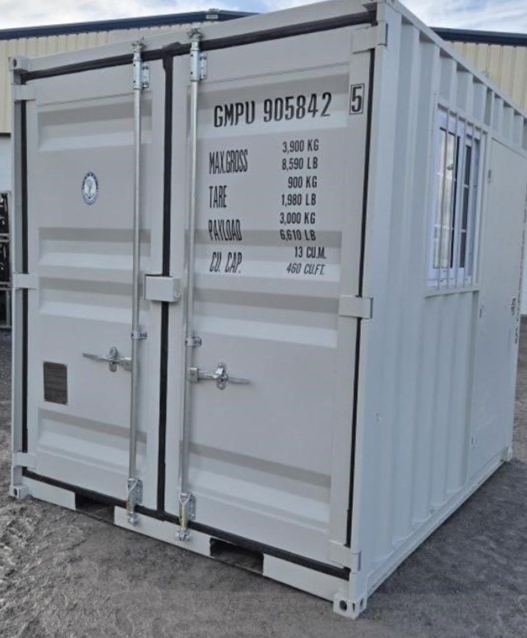 Light grey 9ft cargo doors with max gross, tare, payload and cubic capacity painted in black, a lockbox between the doors and a small plate low on the left door