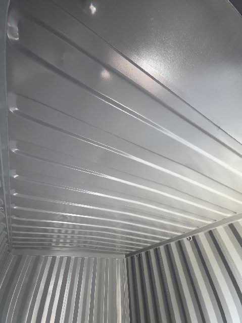 Looking up at the corrugated roof panels inside the 12ft, painted light grey and catching the daylight from the open doors