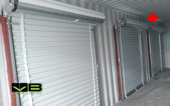 Inside a container storage build with three white roll-up doors along the corrugated wall