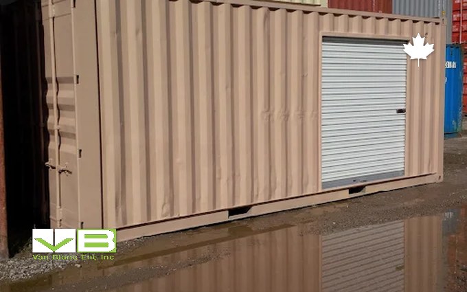 A tan shipping container fitted with a white roll-up door on a yard, the built steel shed that carries an Ontario snow load without clearing